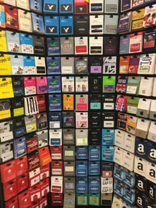 Gift cards for various companies on the endcap at a grocery store